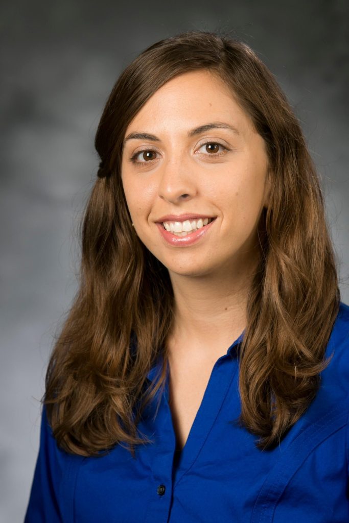 Woman with long brown hair wearing deep blue blouse